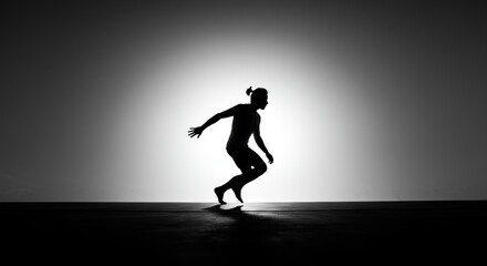 Dramatic silhouette of a modern dancer performing an energetic routine under a bright spotlight