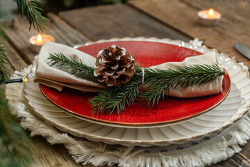 Festive Christmas table setting with plate and napkin decorated pine cone and spruce twig