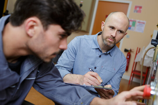 supervisor noting information conveyed by trainee engineer