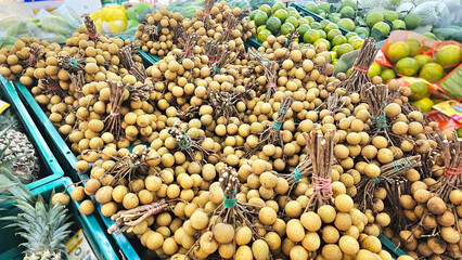 Tropical Fruit Bounty: An abundant display of fresh longans and vibrant limes fills the frame, showcasing the colors and textures of a market.