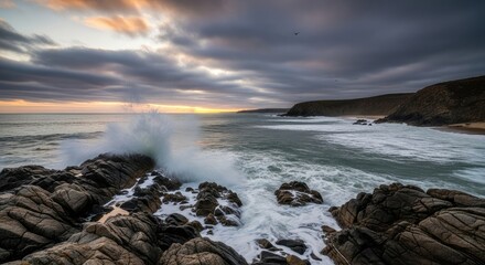 Ocean waves crashing against rocks under cloudy sky at sunset view