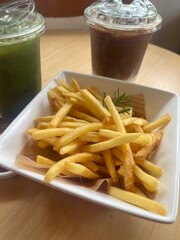 Crispy golden french fries with rosemary and beverages