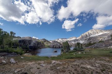 Alpine Lake Surrounded by Rocks and Dynamic Clouds in the Twenty Lakes Basin, Eastern Sierra, California.