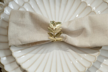White plates decorated napkin and golden ring. Top view. Elegant crockery.
