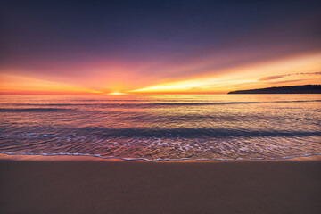 Beautiful golden color sunrise over the sea horizon and beach shore 