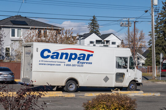 Calgary, Alberta, Canada. Oct 28, 2025. A white Canpar Express delivery truck, a TFI International company, parked on an urban street under a clear blue sky.