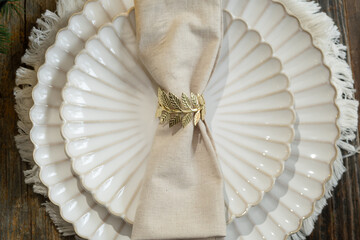 White plates decorated napkin and golden ring. Overhead view. Elegant crockery.