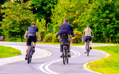 Fototapeta premium Cyclists ride on the bike path in the city Park 