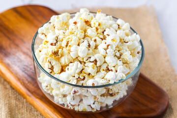 One clear glass bowl with freshly popped, fluffy popcorn. Ready to be enjoyed as a perfect snack for movie nights, parties, or casual indulgence.