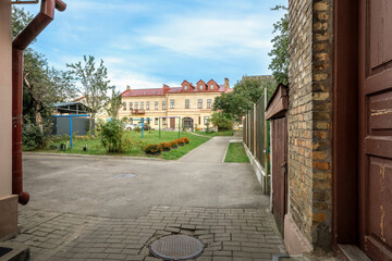 Old courtyard with paved walkway leading to historic residential building