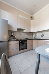 Modern Beige Kitchen with Dining Space and Black Countertop