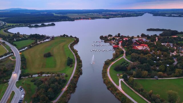 River and highway through green landscape. Drone view showing a river, bridge, and roads curving through scenic countryside.