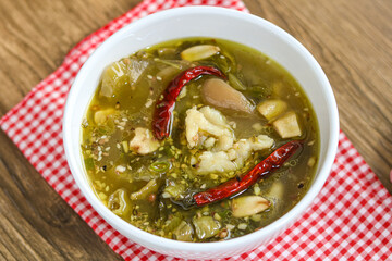 A bowl of Chinese Sauerkraut Fish (Suan Cai Yu), featuring tender fish fillets in a flavorful broth...