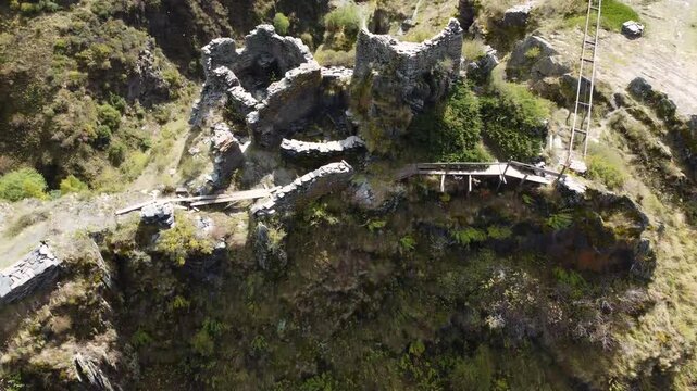 Dynamic drone fly over a mountain range winding around Mutso village historical ruins on rocky landscape, Khevsureti, Mtskheta-Mtianeti, Georgia.