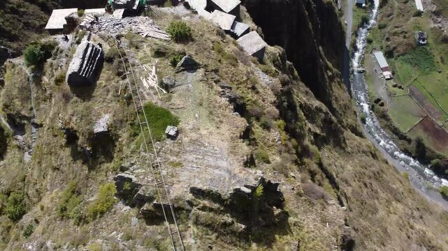 Dramatic drone fly over Mutso small village historical ruins and homes on steep cliff above Andakistskali river, Khevsureti, Mtskheta-Mtianeti, Georgia.
