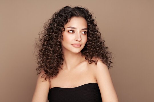 Fashion studio portrait of beautiful smiling woman with afro curly hairstyle. Fashion and beauty