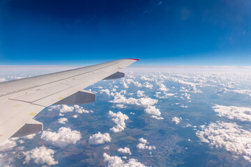 Obraz premium View from the airplane window at a beautiful cloudy sky and the airplane wing