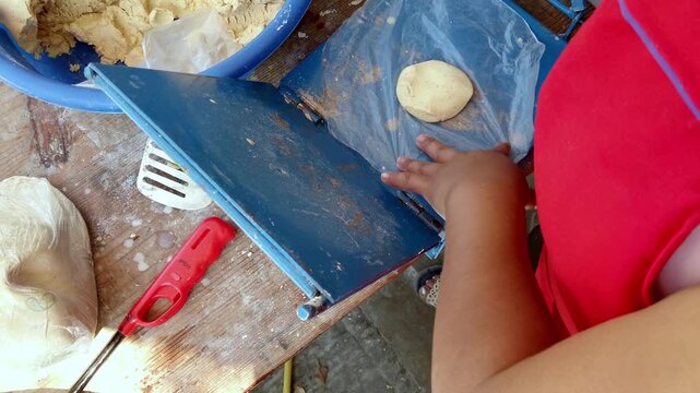 Preparing homemade tortillas using a blue press and fresh masa dough