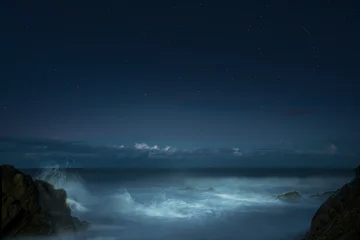 Fototapete Rund Küste Atmospheric night seascape along the Irish coast with silky water, dramatic foreground dark rocks, ethereal waves, and horizon light clouds  © Vitaliy