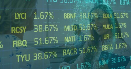 Three colleagues analyzing financial tickers on glass partition in meeting room, with laptop