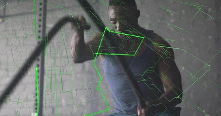Athlete wearing blue tank top and shorts swinging battle ropes in gym, with green wireframe overlay