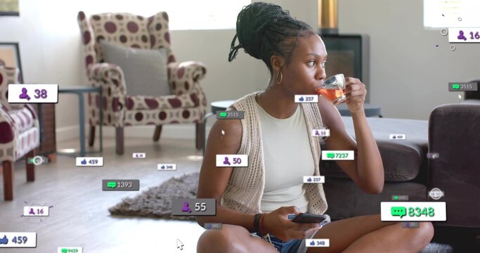 Influencer sipping tea from glass cup and scrolling smartphone at home, with social media icons - Powered by Adobe
