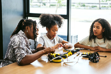 Students collaborate on a robotics project in a bright classroom, assembling electronic components...