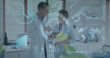 Reviewing tablet display by two doctors in dental exam room, with green chair and digital overlay