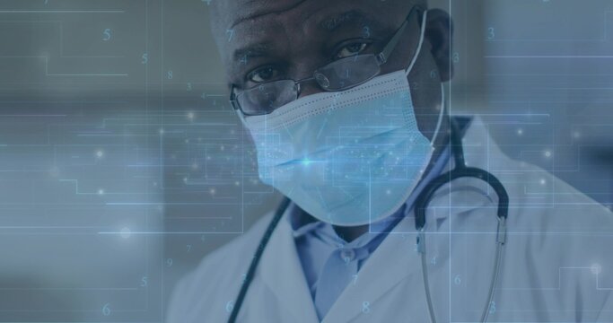 Showing doctor wearing lab coat mask and glasses in clinic, with stethoscope and digital overlay - Powered by Adobe