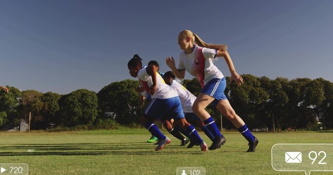 Sprinting five female soccer teammates on grassy soccer field, wearing soccer uniforms and cleats