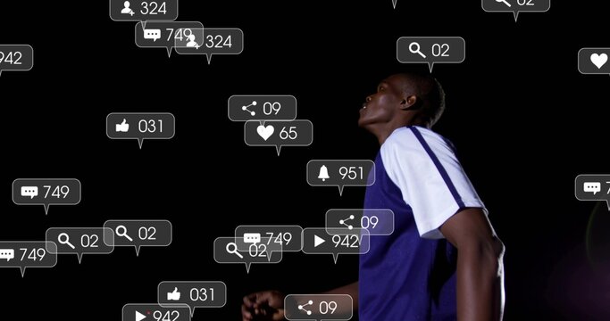 Gazing upward man wearing blue jersey standing in black studio, with notification icons, copy space