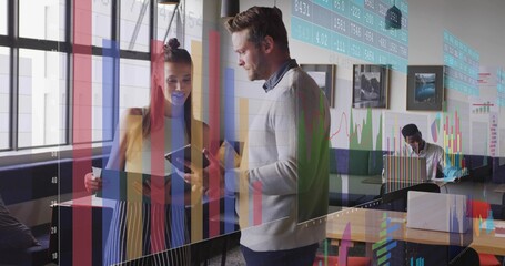 Collaborating over tablet, colleagues standing beside window booth in office with data overlays