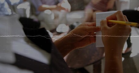 Hands holding yellow pencil writing on white note card in workshop with coffee cup, copy space