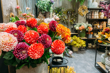 Brightly colored artificial dahlia flowers in a rustic floral shop. Faux botanicals, sustainable retail decor, flower styling, handmade aesthetics