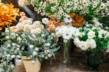 Assorted white and pastel faux florals in mixed textures including daisies, carnations, and lotus pods. Artificial florals, reusable bouquets, sustainable decor, floral styling for events