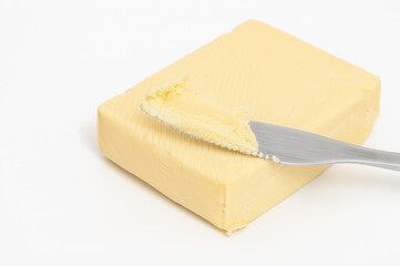 Real butter, a stick of butter on a white background and a spreading knife