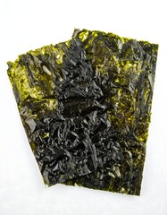 Two sheets of dried seaweed on white background, detailed texture