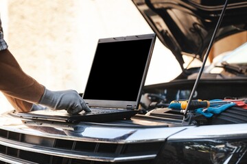 Mechanic uses a laptop to record error engine checks