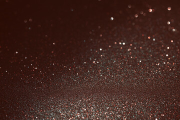 Shimmering crimson glitter background with cool highlights, lower frame reveals fine textured detail while upper background melts into soft glowing blur