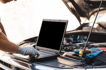 Mechanic uses a laptop to record error engine checks