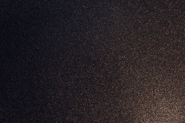 Dark granular glitter background enriched with golden sparkles, warm diagonal light from bottom right forms elegant gradient blending into shadow