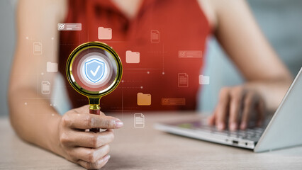 Secure file search with magnifying glass, woman reviewing digital folders on laptop