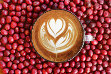 a cup of latte art coffee with fresh coffee beans for background                                                     