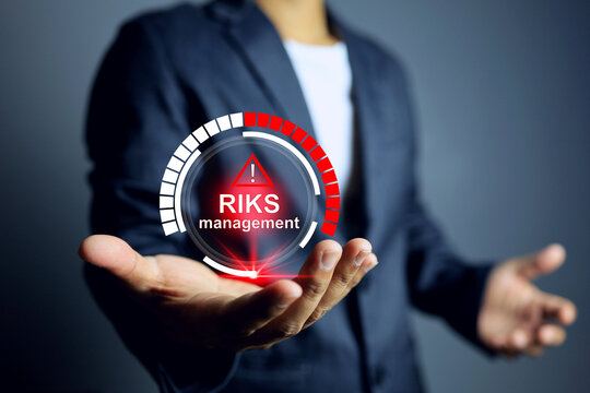 risk management concept with businessman holding infographic represent to reduce a risk factor in company to zero or acceptable level