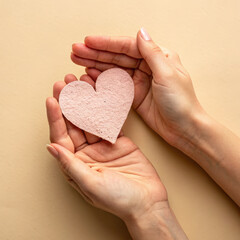 Obraz premium Sustainable living concept with hands gently holding pink heart shape symbolizing care and love for environment and future generations