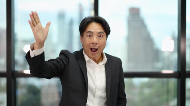 Asian Businessman Gesturing and Speaking in Modern Office Window