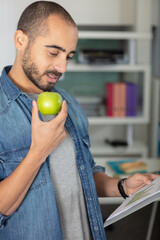 happy businessman eating an apple in the office