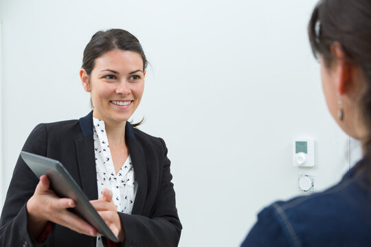 woman with tablet near security system indoors