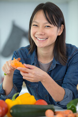 asian woman cooking vegetables in the kitchen in her apartment