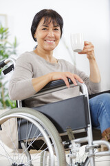 senior woman in wheelchair drinking coffee indoors